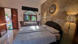 甘地达萨Catra homestay beach apartments的一间卧室配有一张床和一张桌子及椅子