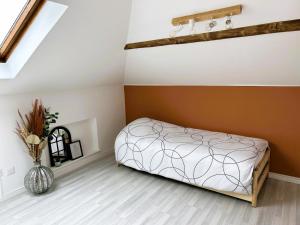 蓬塔穆松Appartement climatisé Le Gambetta的卧室配有一张床,地板上设有花瓶