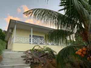 马埃岛Naturalis - Oceanview Residences的前面有楼梯的黄色房子