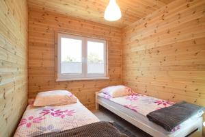 萨比诺瓦Kalimera的小木屋内一间卧室,配有两张床