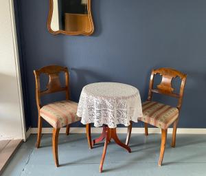 SauvoVinter Bed & Breakfast的一张桌子和两把椅子,配有一张桌子和一面镜子