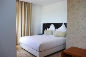 达赫拉Hôtel Mansour的一张大白色的床,位于酒店客房内
