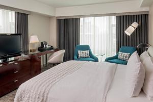 剑桥剑桥波士顿艾美酒店的酒店客房,配有一张床和两张蓝色椅子