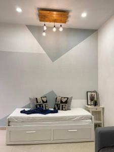 安顺Cozy 119 Homestay Teluk Intan的卧室配有一张白色墙壁的床