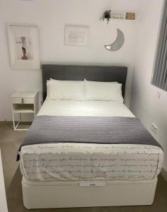卡尼亚达新镇Apartamento moderno y centrico的一张白色的床,位于带床架的房间