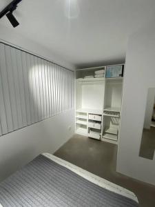 卡尼亚达新镇Apartamento moderno y centrico的白色的客房配有一张床和一个衣柜
