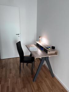 贝尔吉施格拉德巴赫Moderne Wohnung mit Loggia - Neubau 2023的一张木桌、椅子和灯