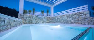 扎金索斯镇Dion Villa Zakynthos Greece的一座带石墙的大型游泳池
