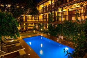 达累斯萨拉姆普罗蒂亚万怡酒店的一座游泳池,在晚上在建筑物前