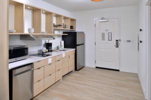 阿什维尔TownePlace Suites by Marriott Asheville Downtown的厨房配有木制橱柜和冰箱。