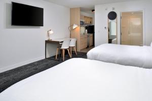 阿什维尔TownePlace Suites by Marriott Asheville Downtown的酒店客房配有两张床和一张书桌