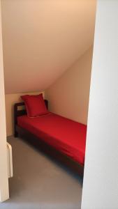 莱代塞尔Appartement Le Montagnard的红色的床,红色枕头,放在房间里