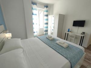 卡利亚里Iris Rooms的卧室配有一张白色大床和两条毛巾