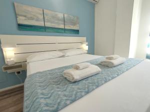 卡利亚里Iris Rooms的一间卧室配有一张床,上面有两条毛巾