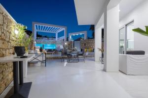 扎金索斯镇Dion Villa Zakynthos Greece的开放式客厅设有石墙和白色地板。