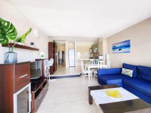 阿德耶Ocean View Villas Canarias的一间带蓝色沙发的客厅和一间厨房