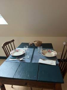 朗波普卢阿尔泽La vigie d'Héloïse, appartement de l'Aod的一张带盘子和眼镜的蓝色桌子