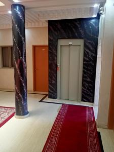 盖勒敏Hotel Tidinit的大房间,有红地毯和门
