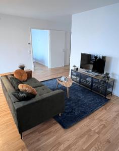 贝尔吉施格拉德巴赫Moderne Wohnung mit Loggia - Neubau 2023的带沙发和电视的客厅