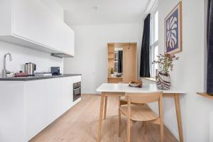哥本哈根司丽普旅舍的一间厨房,里面配有白色的桌子和椅子