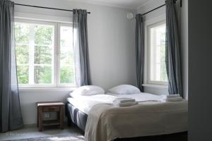 瑙沃Gammelgård Pizza & Padel Resort的一间卧室设有两张床和两个窗户。