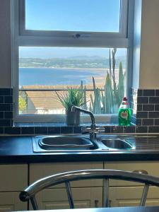 本莱赫Apartment 3 Benllech with Sea views的厨房水槽和海景窗户