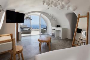 易莫洛林Theano Cave Suites & Villas的一间卧室配有一张床,享有海景