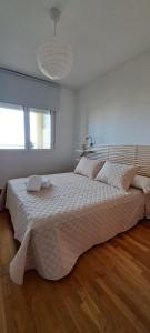 马拉加Litoral beach的一间卧室配有一张大床和一张白色的大床罩