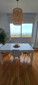马拉加Litoral beach的窗户客房内的白色桌椅