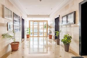 拉巴特Appartement Rabat Agdal City Centre - SwiftStay的楼内带有盆栽的走廊