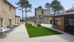 拉赫A Casa de Elisa的绿色草坪上带桌椅的庭院