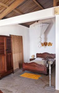 贝岛Hôtel chez Pat的一间卧室配有一张床、一张桌子和风扇