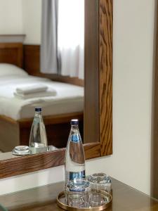 普拉夫Apartments & Rooms Brijest的镜子前桌子上放着两瓶和眼镜