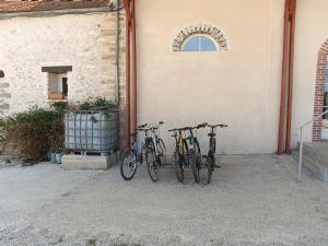 ChampcenestChambre d'hôtes Le Domaine des Hirondelles的三辆自行车停在大楼旁边