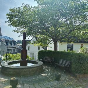 锡根Rubens Haus的两排长椅和一棵树的院子中的喷泉