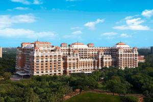 钦奈ITC Grand Chola, a Luxury Collection Hotel, Chennai的前面有树木的大建筑