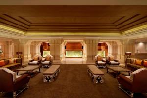 钦奈ITC Grand Chola, a Luxury Collection Hotel, Chennai的一间大房间,位于一座建筑中,配有沙发和椅子