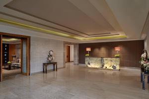 钦奈ITC Grand Chola, a Luxury Collection Hotel, Chennai的大堂,带壁炉和鲜花的酒店