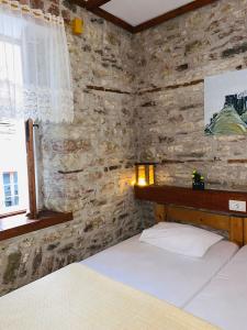 吉诺卡斯特Guest House and Hostel VAL-MAR的一间卧室设有两张床和石墙