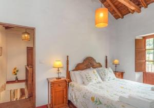 贝瑙汉Molino del Caracol的一间卧室配有一张床、两盏灯和一面镜子