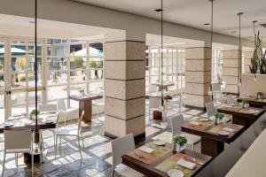洛杉矶喜来登环球酒店的餐厅设有桌椅和大窗户。