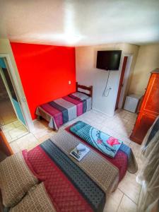 特雷索波利斯Pousada do Gil的一间设有两张床和红色墙壁的客房