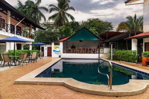 曼努埃尔安东尼奥Condiminium Villas Mymosa的一个带桌椅的度假村游泳池
