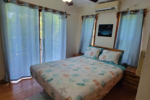 罗阿坦Casa Sueño Caribeño的一间卧室配有蓝色窗帘的床