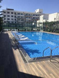 班加罗尔VRR Astoria Hotel & Convention Center的大楼内带躺椅的大型游泳池