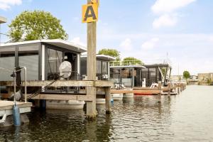 泽沃德Cosy tiny houseboats near beach and restaurants的两艘船停靠在水面上的码头