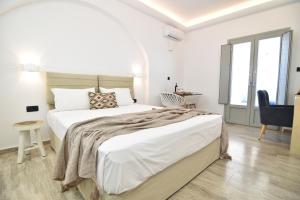 佩里萨艾吉爱斯酒店的白色卧室配有一张大床和椅子