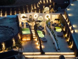 易莫洛林Theano Cave Suites & Villas的享有房子空中景色,晚上设有游泳池