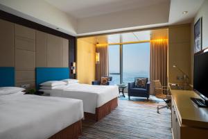 惠州惠州富力万丽酒店的酒店客房设有两张床和一台平面电视。