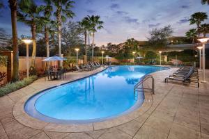 玛丽湖奥兰多万豪酒店玛丽湖的一个带桌椅和棕榈树的大型游泳池